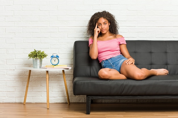 Femme assise sur le canapé