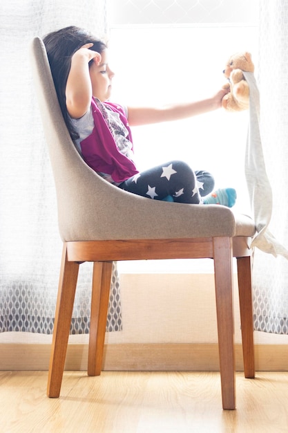 Photo femme assise sur une chaise à la maison