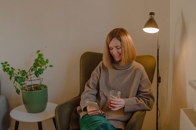 Femme assise sur une chaise avec un téléphone dans les mains