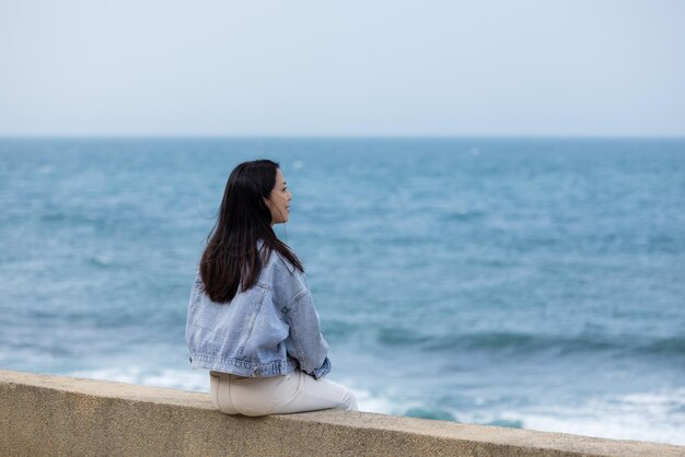 Une femme assise à côté de la plage