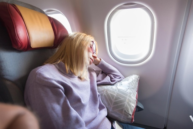 Une femme assise dans un avion.