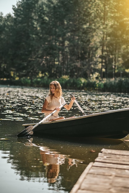 Une femme assise dans un bateau et ramant