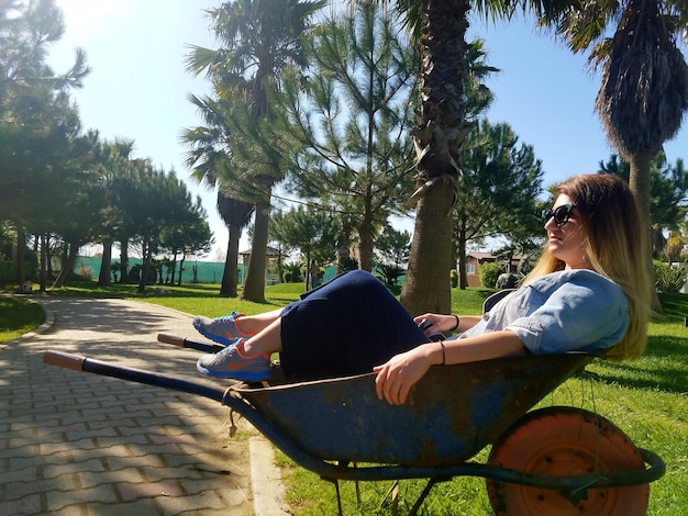 Photo une femme assise dans une brouette dans le parc