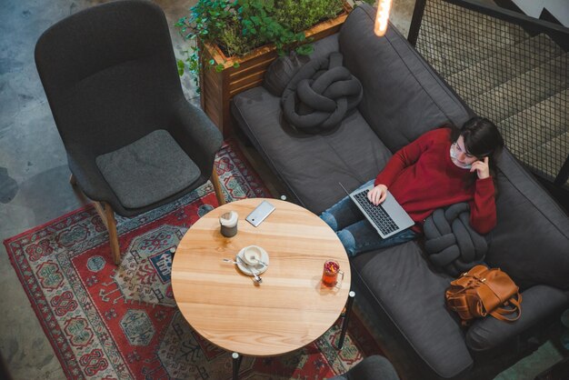 femme assise dans un café en utilisant un ordinateur portable buvant du thé écran blanc copie de l'espace style de vie