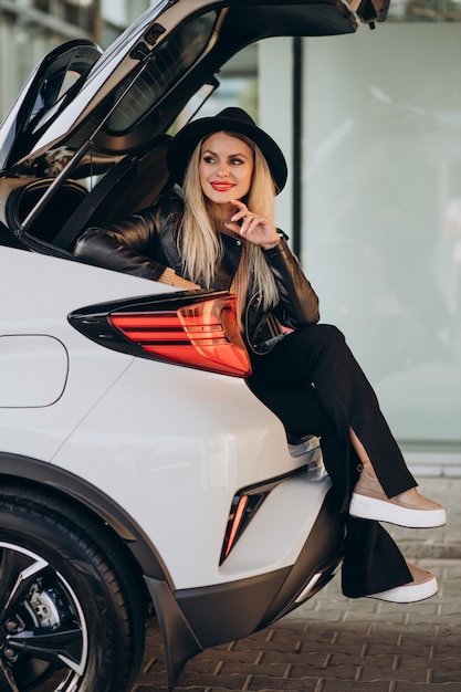 Femme assise dans le coffre de sa voiture