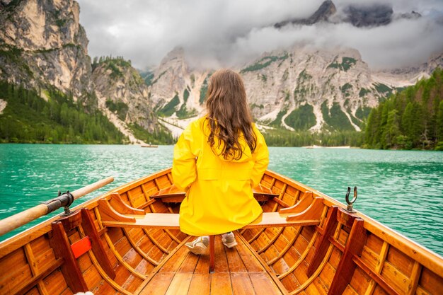 Femme assise dans un grand bateau brun au lac de Lago Braies un jour nuageux en Italie vacances d'été en Europe