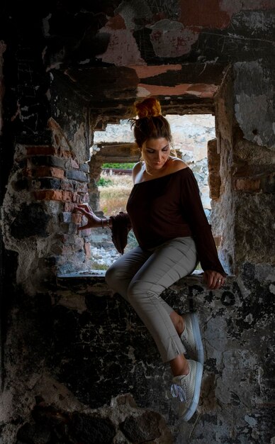 Photo une femme assise dans un immeuble abandonné.