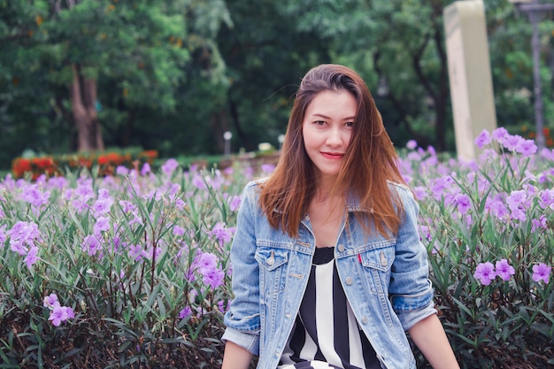 Femme assise dans un parc où les fleurs s'épanouissent magnifiquement.