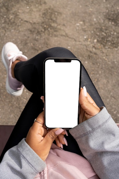 Femme assise dans un parc avec un téléphone portable