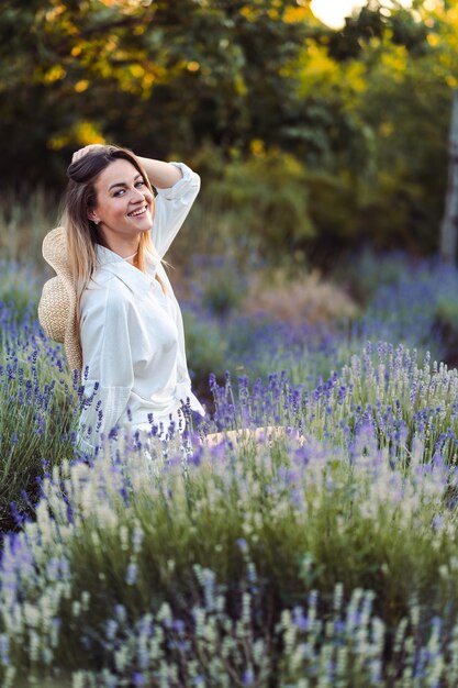 Femme assise dans la prairie de lavande et apprécie la beauté et le parfum