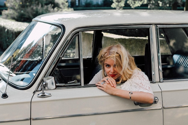 Une femme assise dans une vieille voiture.