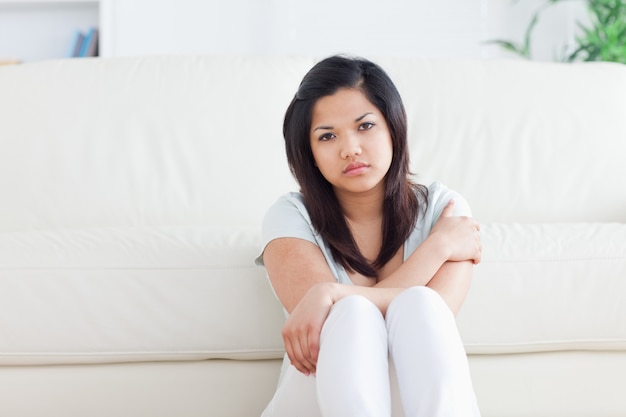 Femme assise devant un canapé