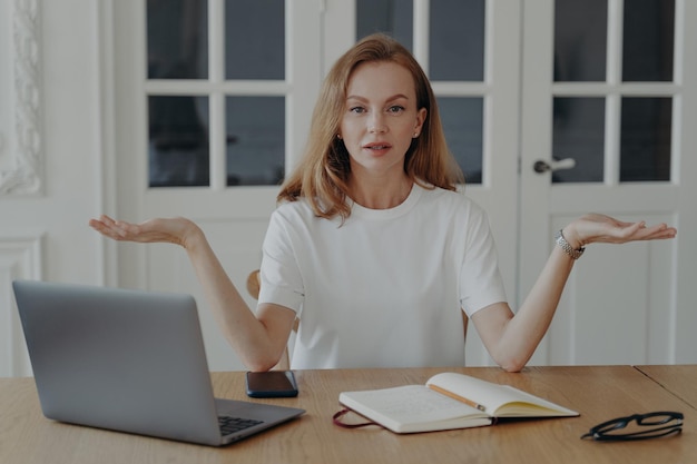 Une femme assise devant un ordinateur portable montre deux espaces de copie vides présentant des produits ou services alternatifs