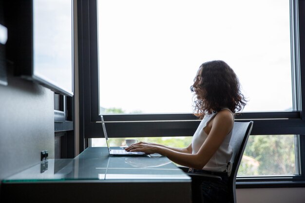 Photo femme assise devant son ordinateur, femme travaillant à domicile, étudiant et son ordinateur, pe