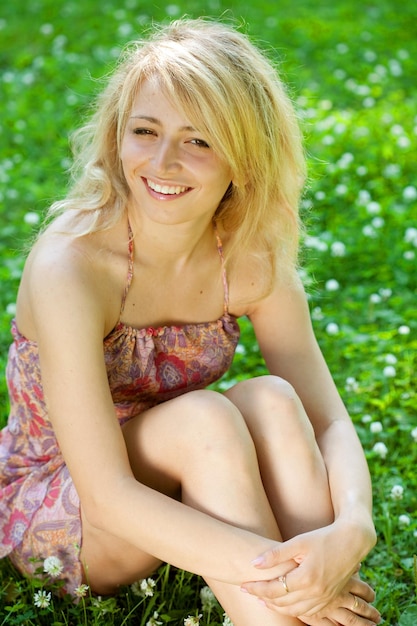 Femme assise à l'extérieur en souriant