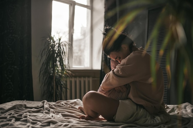 Une femme assise à la fenêtre.