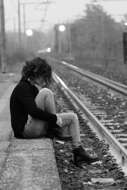 Photo une femme assise à la gare.