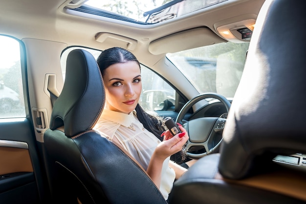 Femme assise à l'intérieur de la nouvelle clé d'offre de voiture