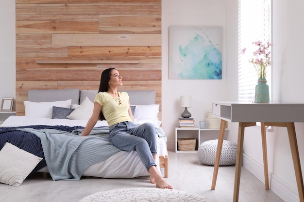 Femme assise sur le lit dans une chambre moderne Intérieur élégant