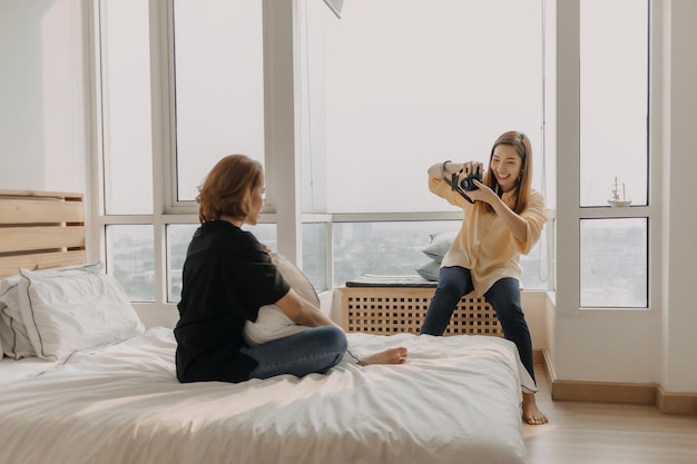 Une femme assise sur le lit dans la chambre.