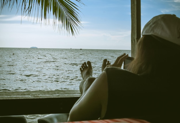 Photo une femme assise sur la plage contre le ciel