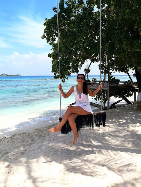 Une femme assise sur la plage contre le ciel