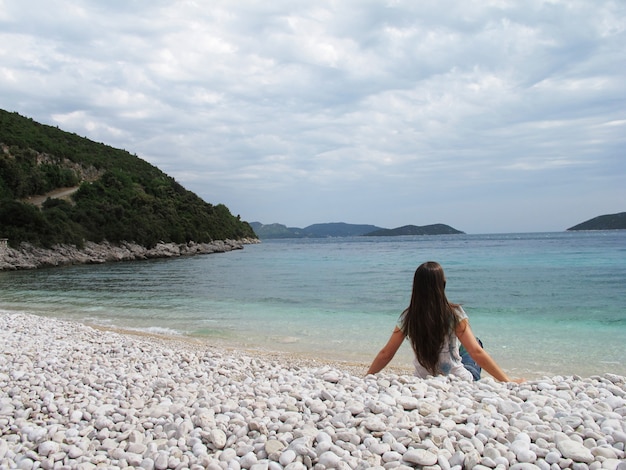Femme assise sur une plage de galets en Croatie