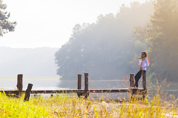 Femme assise sur un pont en bois