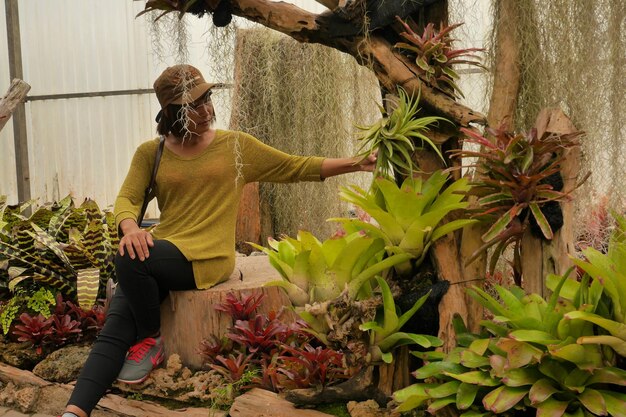 Photo une femme assise près des plantes dans le parc