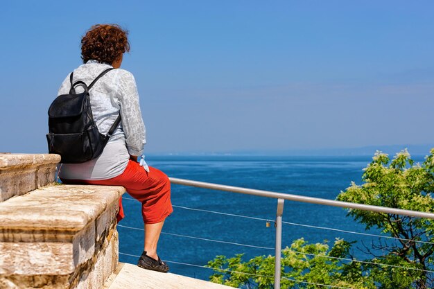 Photo femme assise et regardant la nature et la mer adriatique au parc national de strunjan en slovénie