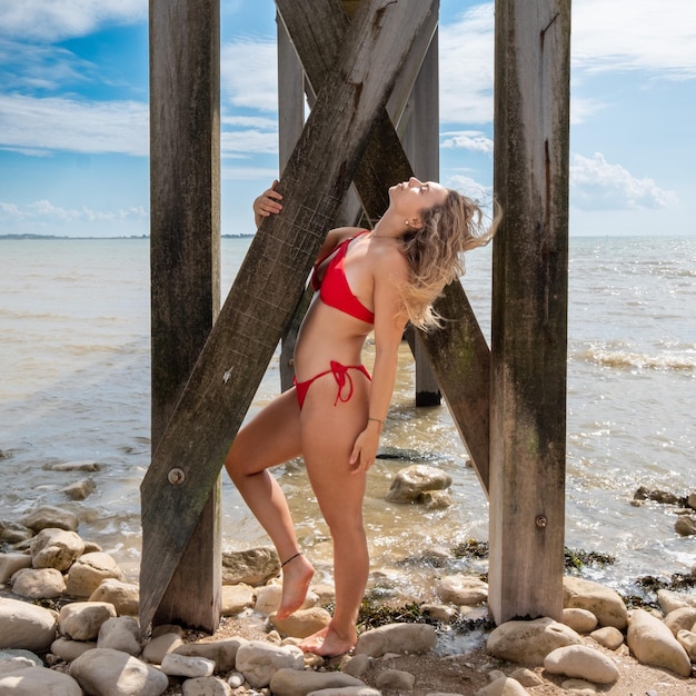 Une femme assise sur un rocher sur la plage.