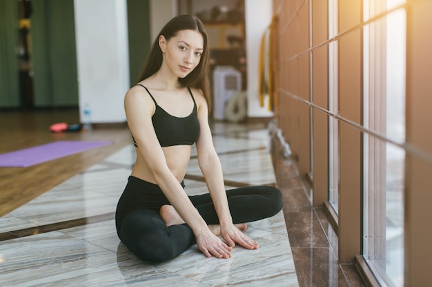 Femme assise sur le sol du gymnase