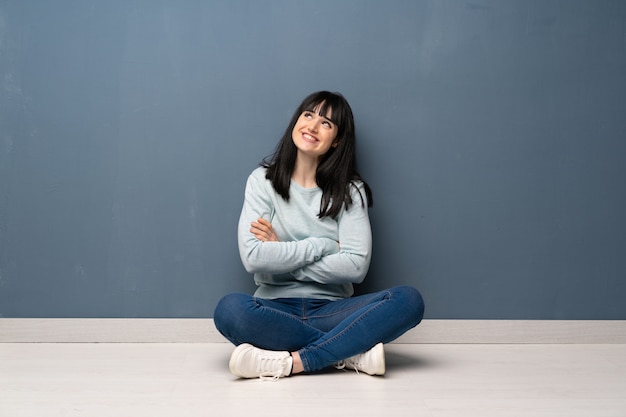 Femme assise sur le sol en levant en souriant