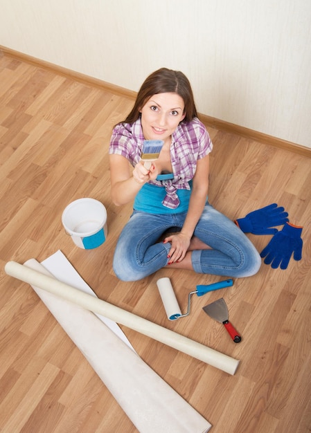 Femme assise sur le sol parmi les outils de décoration