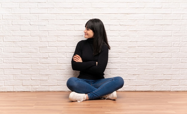 Femme assise sur le sol en position latérale