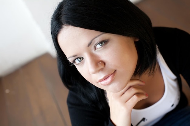 Femme assise et souriante à l'intérieur