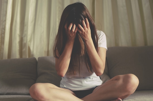 Une femme assise stressée, déprimée, insomniaque qui a rompu avec son copain.