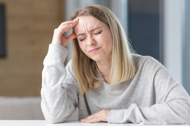 femme assise à une table au bureau douleur intense