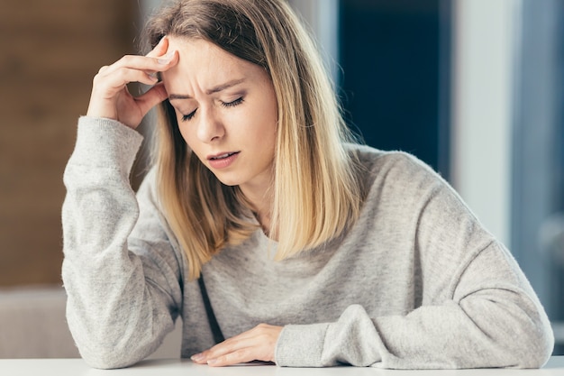 femme assise à une table au bureau douleur intense