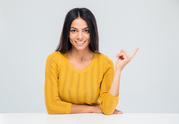 Femme assise à la table et doigt pointé