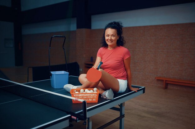 Femme assise sur une table de ping-pong