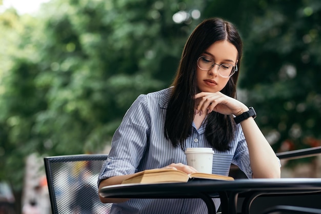 Femme assise sur la terrasse et livre de lecture