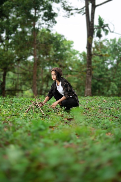 Photo une femme assise sur la terre dans la forêt