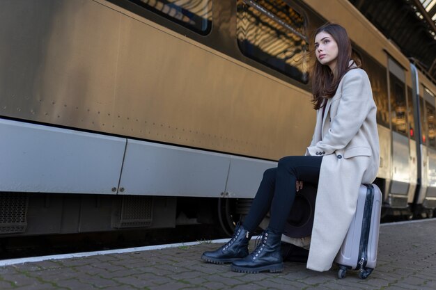 Femme assise sur une valise