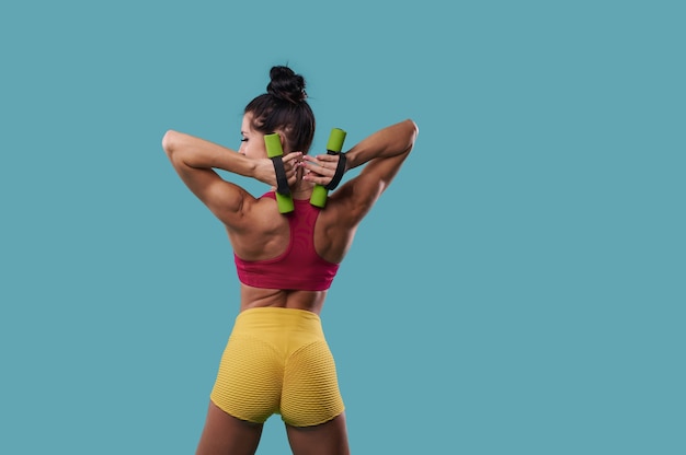 Femme athlétique avec un corps musclé parfait secoue les triceps