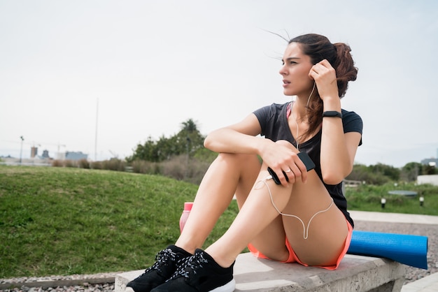 Femme athlétique, écouter de la musique sur une pause de la formation.