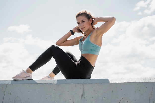 Femme athlétique entraînement en plein air actif étirement et vêtements de sport d'échauffement corporel