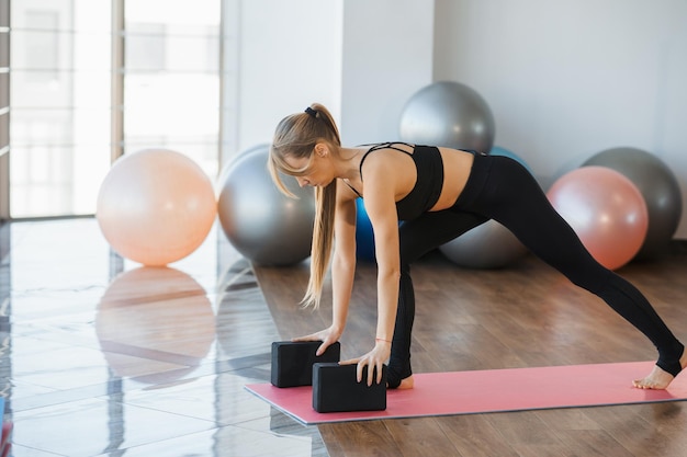 Femme athlétique faisant de l'exercice avec des blocs de yoga