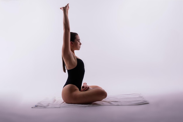 Une femme athlétique en maillot de bain faisant de la pose de planche de yoga variation belle femme faisant de l'exercice en studio