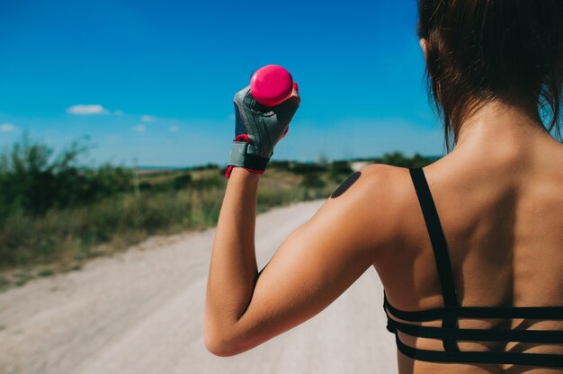 femme athlétique pompage des muscles avec des haltères